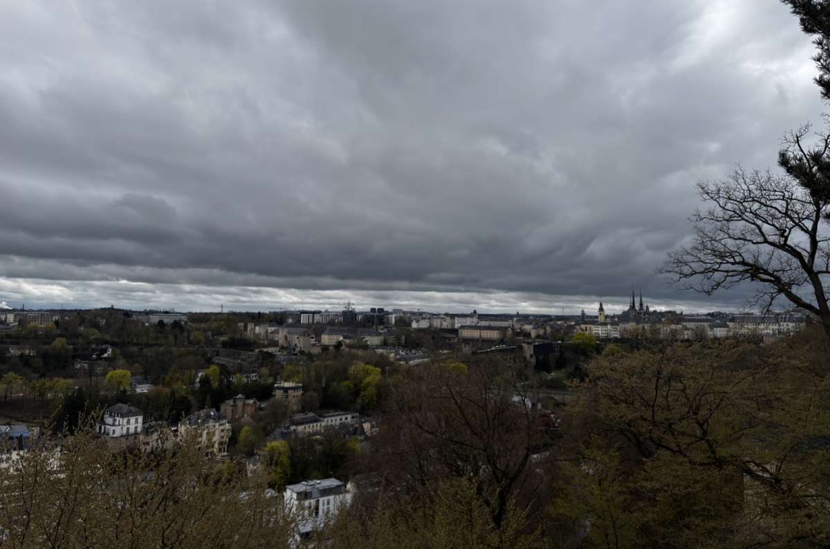 a photo of the red bridge and modern city rising above the green valley, Luxembourg City, Luxembourg, photo by Next Level of Travel
