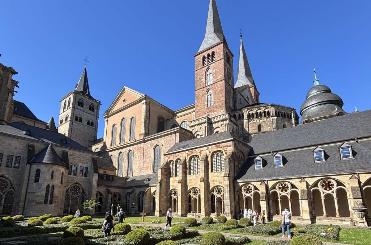 a photo of Trier Cathedral's towers and spire seen across the cloister garden, Trier, Germany, photo by Next Level of Travel