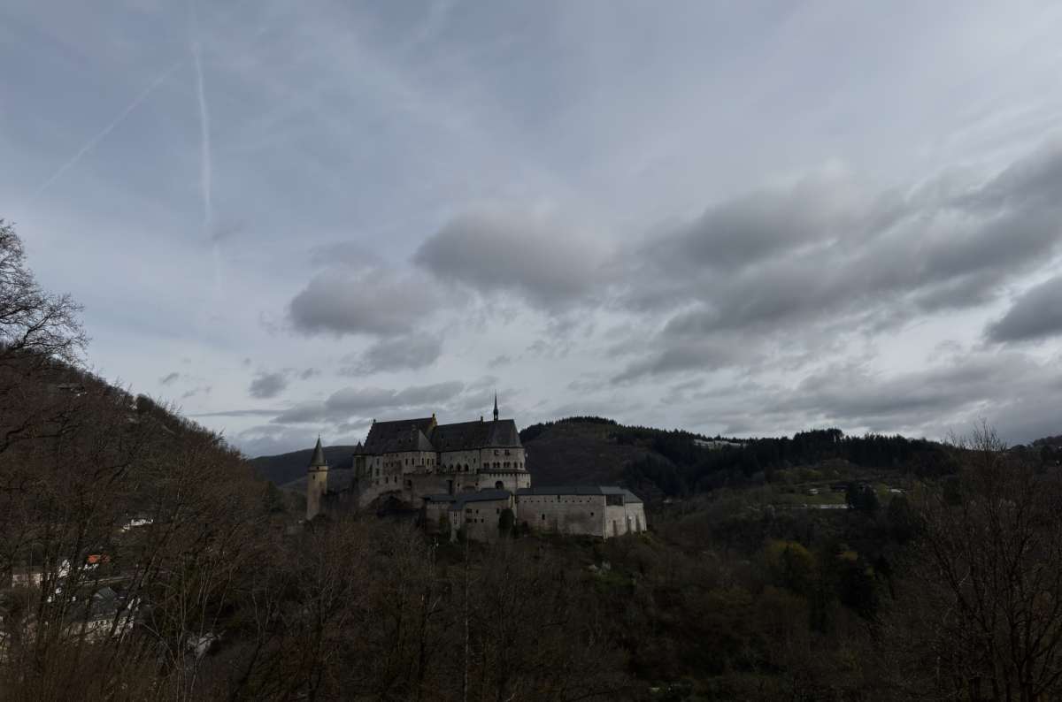 a photo of Vianden Castle on its forested ridge across the valley, Vianden, Luxembourg, photo by Next Level of Travel
