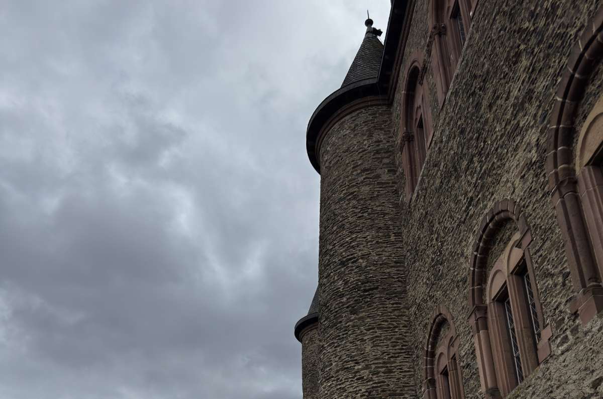 a photo of Vianden Castle rising above the lanes and rooftops of Vianden town, Vianden, Luxembourg, photo by Next Level of Travel 