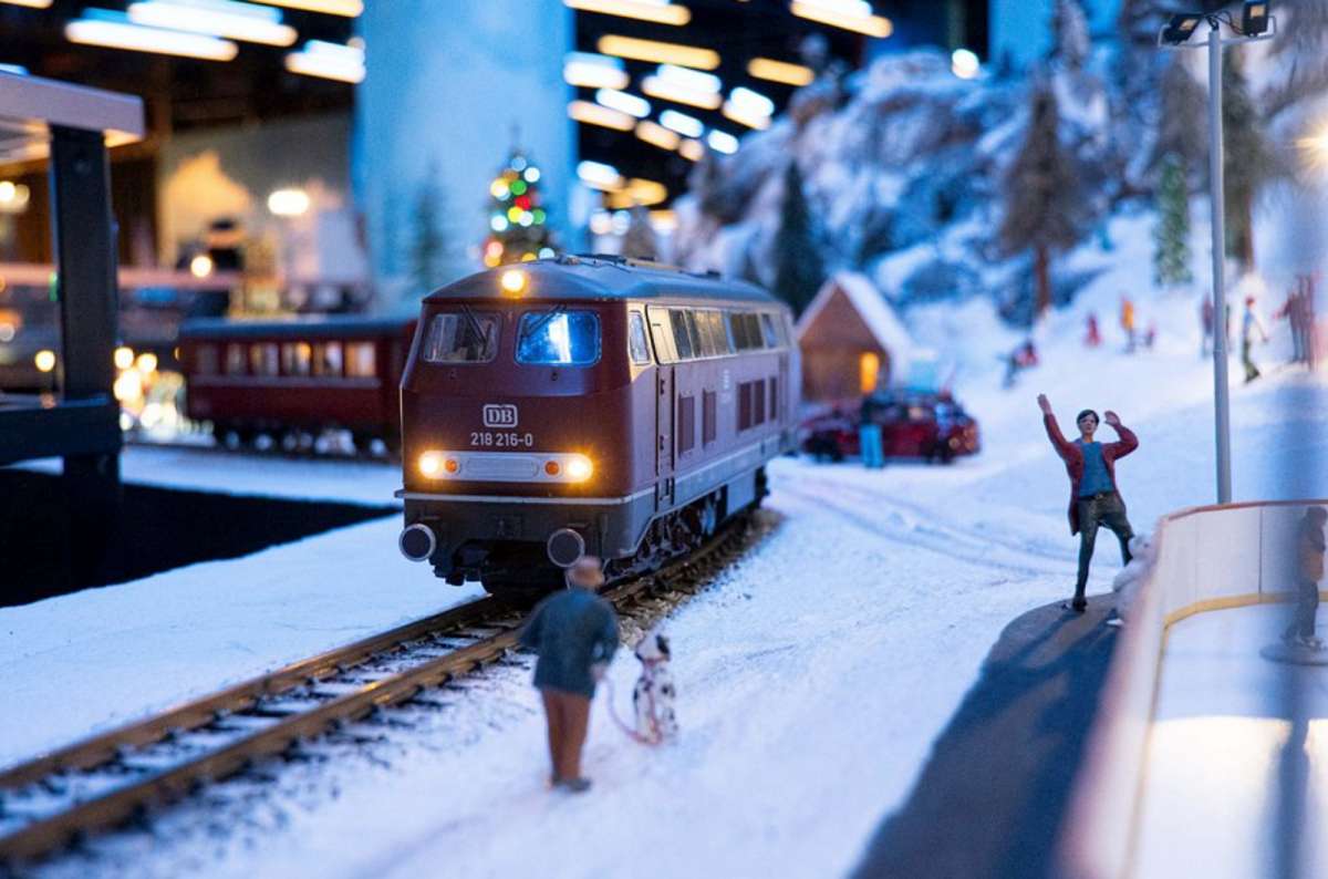 a miniature depiction of a train passing by in the snow and people wawing at it, mini Wroclaw at Kolejkowo, Poland
