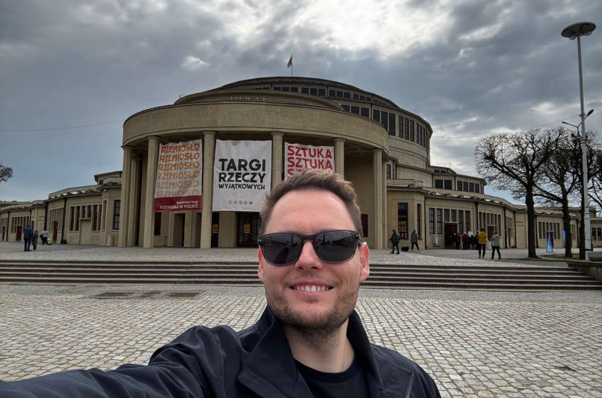 a tourist taking a selfie in front of the Centenial Hall and Japanese  Gardens in Wroclav, Poland, photo by Next Level of Travel