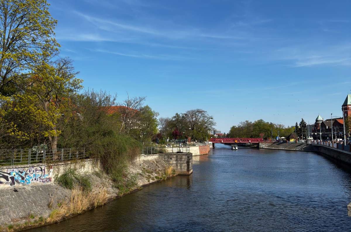 the Oder river separating the Cathedral Island from the rest of Wroclaw with a bridge visible in the background, Poland, photo by Next Level of Travel