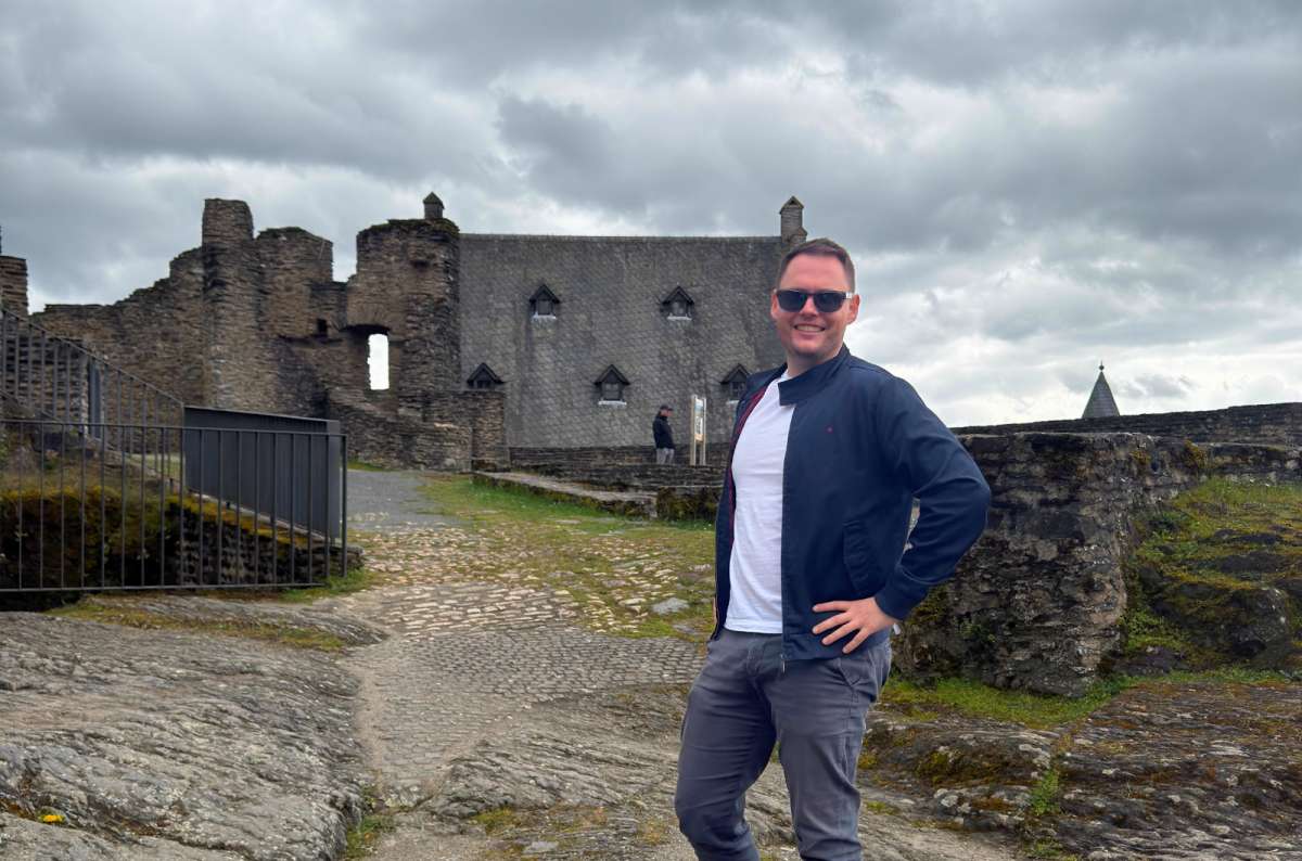 tourist standing infront of the castle ruins, Bourscheid Castle, Luxembourg, photo by Next Level of Travel