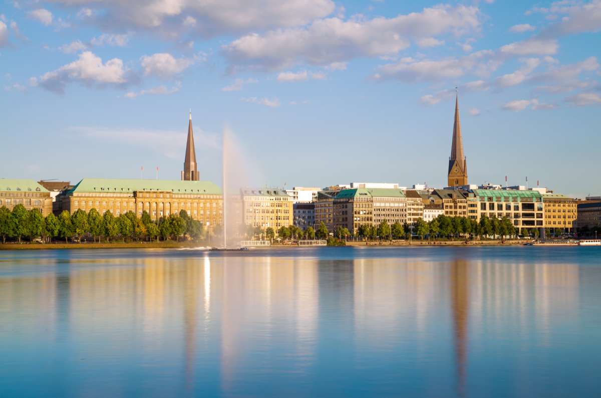 a photo from across the Alster lakes showing the Hamburg city skyline in the background, Hamburg, Germany