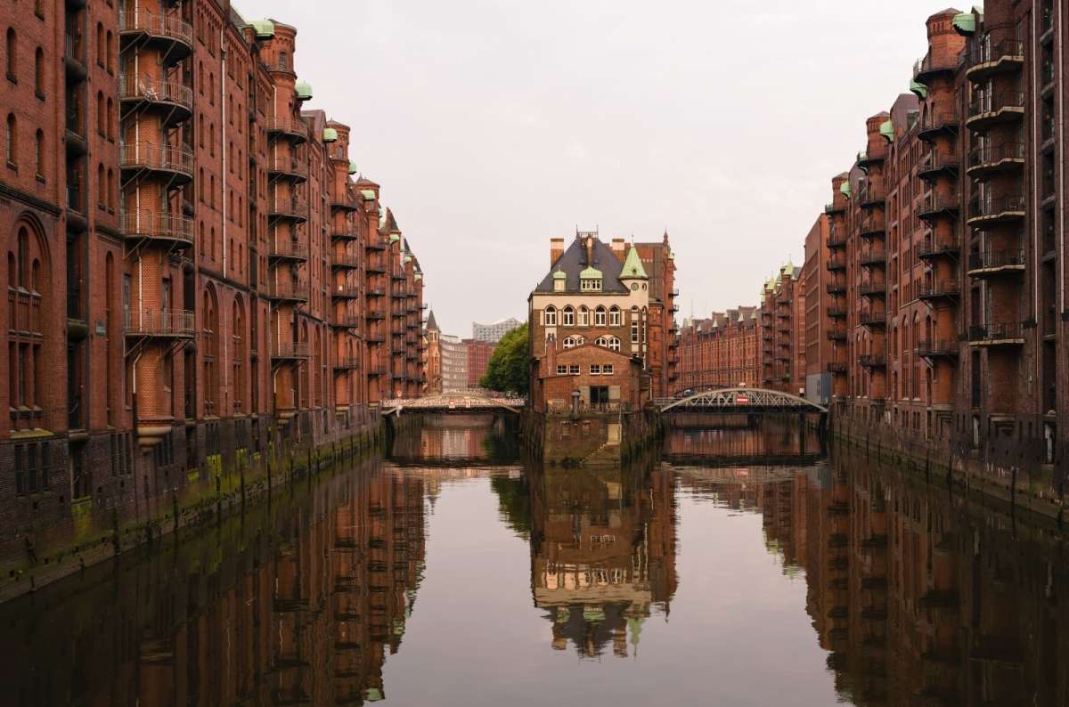 a photo from HafenCity showing the Wasserschloss viewpoint in the center of the frame and characteristic buildings on the sides, Germany