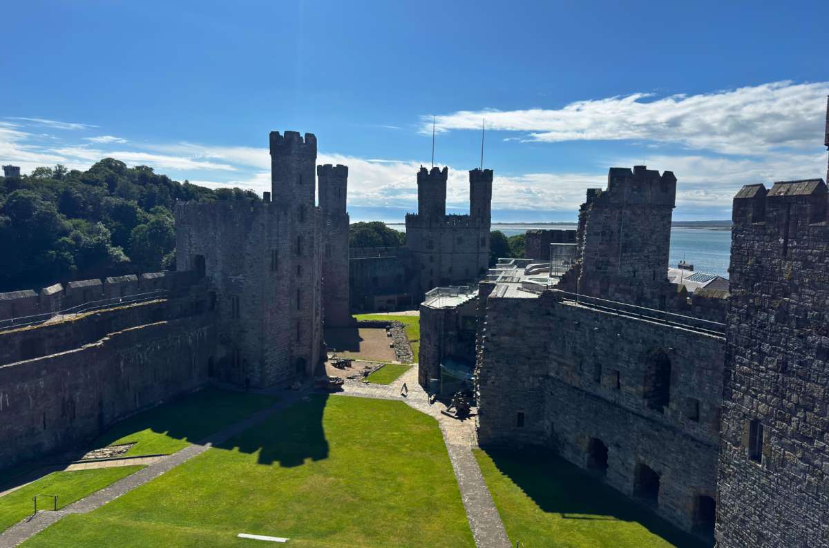 a photo of the towers and courtyard of Caernarfon Castle overlooking the water, North Wales, photo by Next Level of Travel