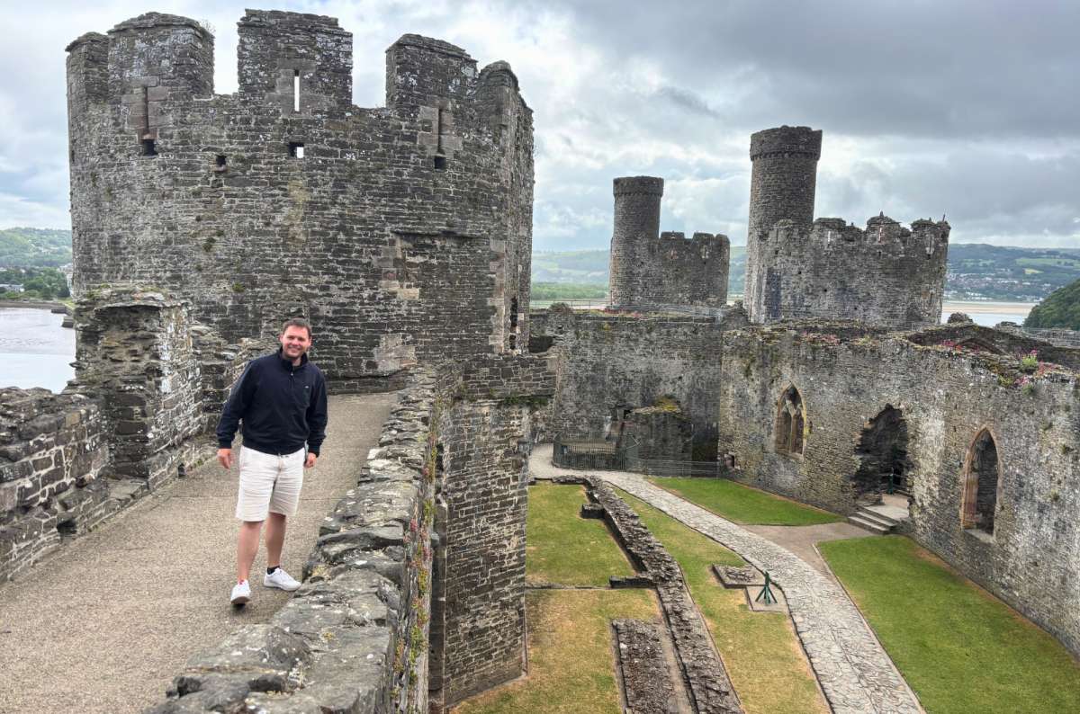 photo of a tourist walking the battlements at Conwy Castle, North Wales, photo by Next Level of Travel