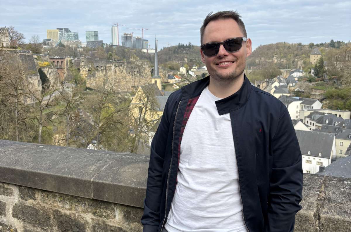 a tourist looking out over Luxembourg City's old town and the Alzette valley from a fortification wall, Luxembourg, photo by Next Level of Travel
