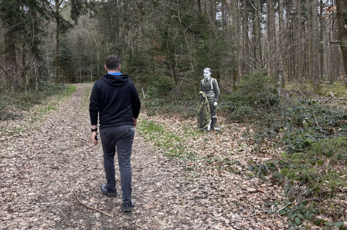 A tourist walking the wooded Schumannseck battlefield memorial trail, Schumannseck, Luxembourg, photo by Next Level of Travel