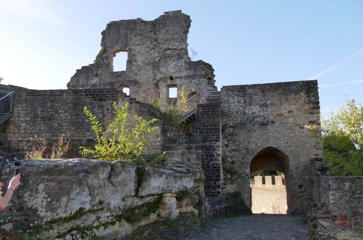 The ruined walls and stone gateway arch of Larochette Castle on its rocky perch above the village, Larochette, Luxembourg, photo by Next Level of Travel