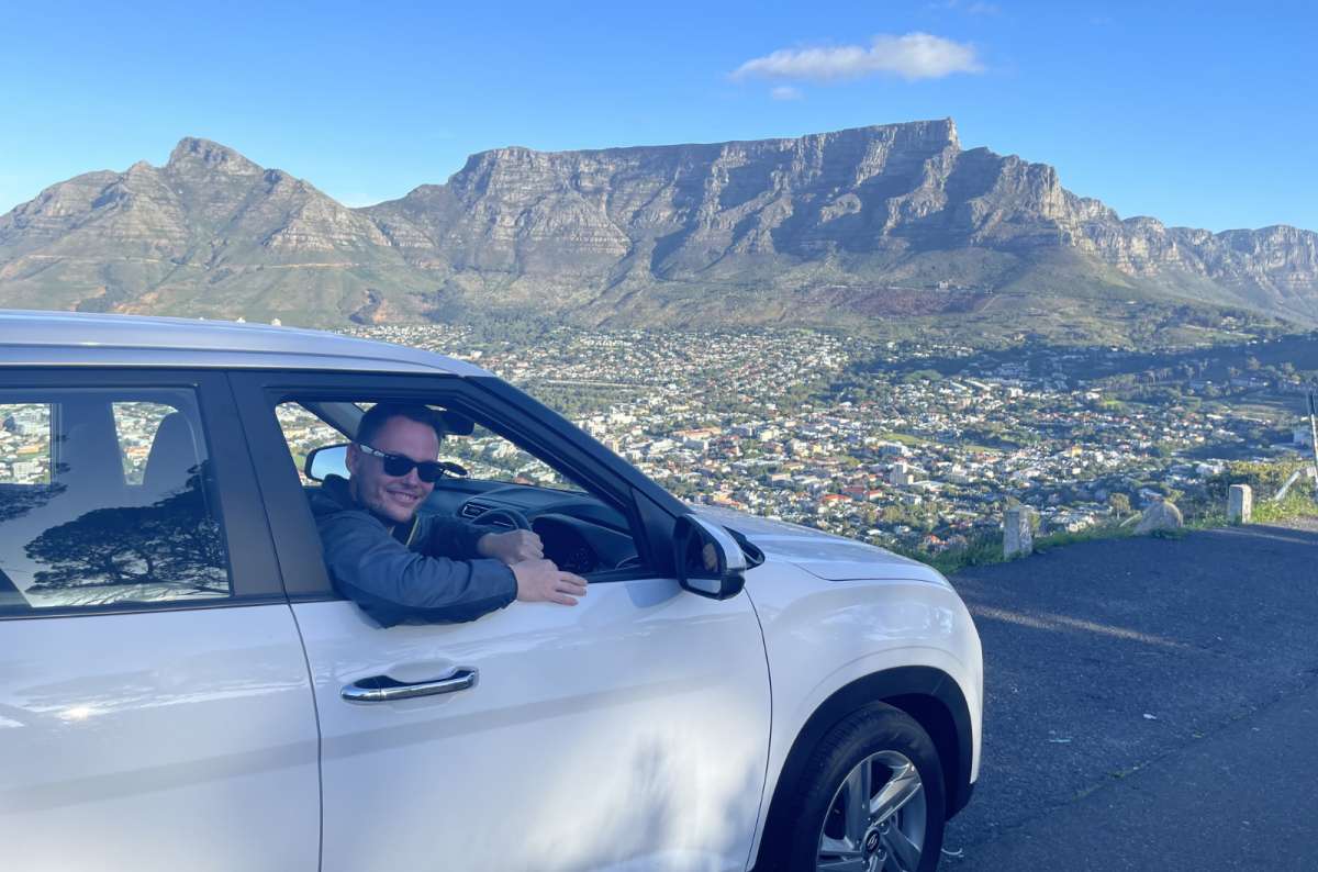 Rental car overlooking Table Mountain from a scenic viewpoint in Cape Town, South Africa, photo by Next Level of Travel