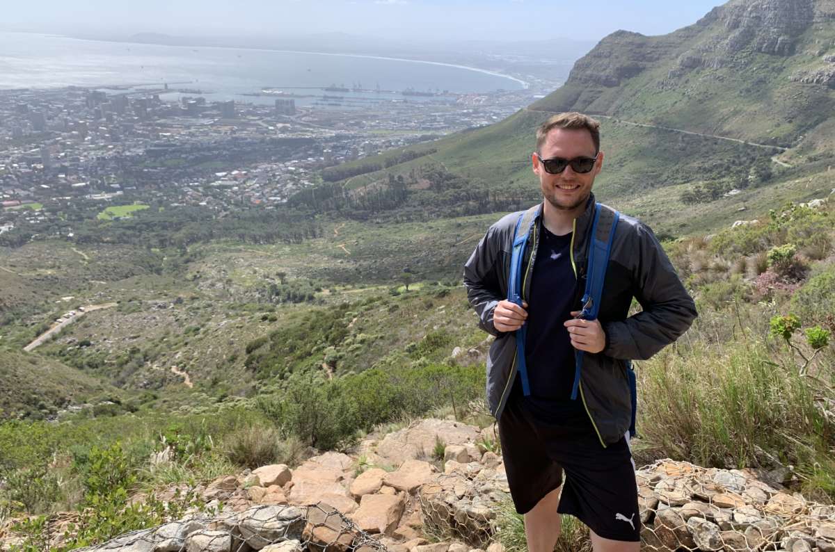 Tourist hiking above Cape Town with views of Table Bay and the city from Table Mountain National Park, South Africa, photo by Next Level of Travel