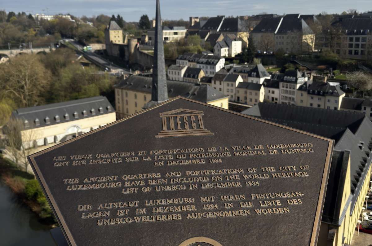 a photo of a UNESCO plaque for the quarters and fortifications of Luxembourg City, with the Alzette valley and Grund quarter below, Luxembourg, photo by Next Level of Travel