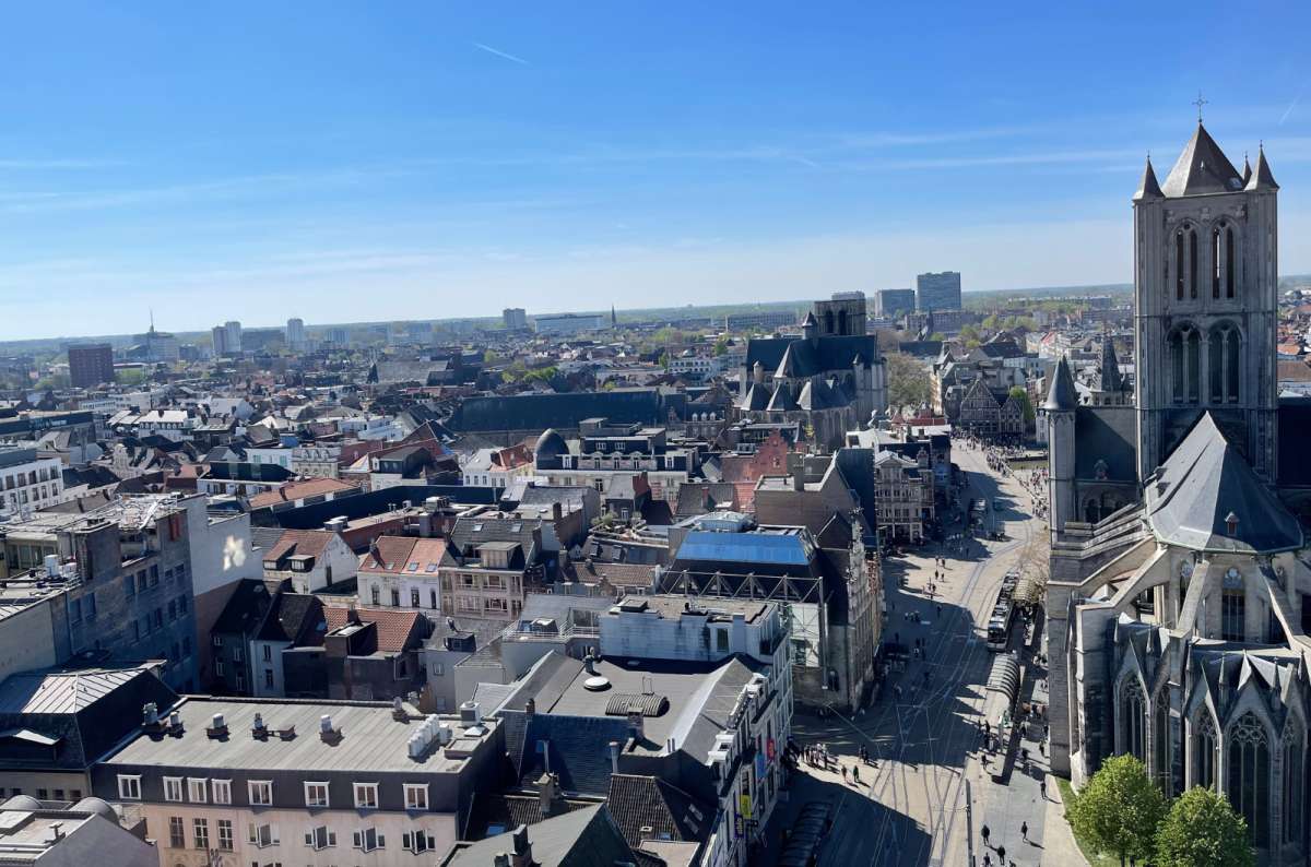 a photo of the Ghent city skyline with the Sint-Niklaaskerk tower and historic rooftops viewed from above on a sunny day, Ghent, Belgium, photo by Next Level of Travel