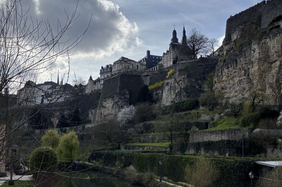 a photo of the old town cliffs and fortification walls of Luxembourg City rising above terraced gardens along the Alzette Valley, Luxembourg, photo by Next Level of Travel