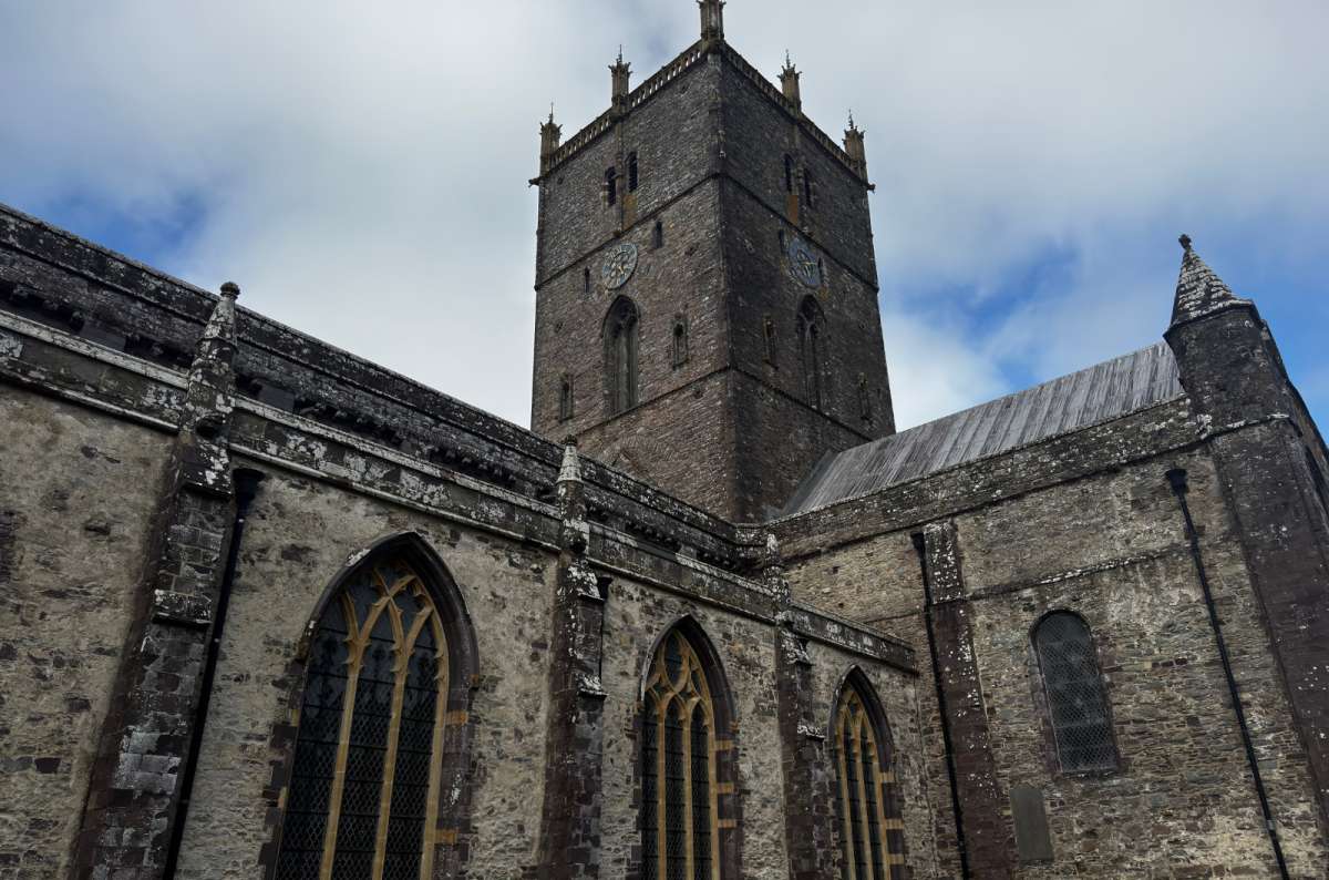 a photo of the tower and Gothic windows of St Davids Cathedral under a grey sky, St Davids, Wales, photo by Next Level of Travel