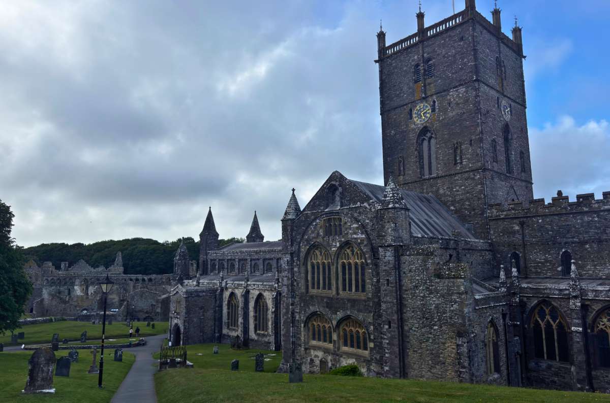 a photo of St Davids Cathedral below its grassy valley under a grey sky, St Davids, Wales, photo by Next Level of Travel