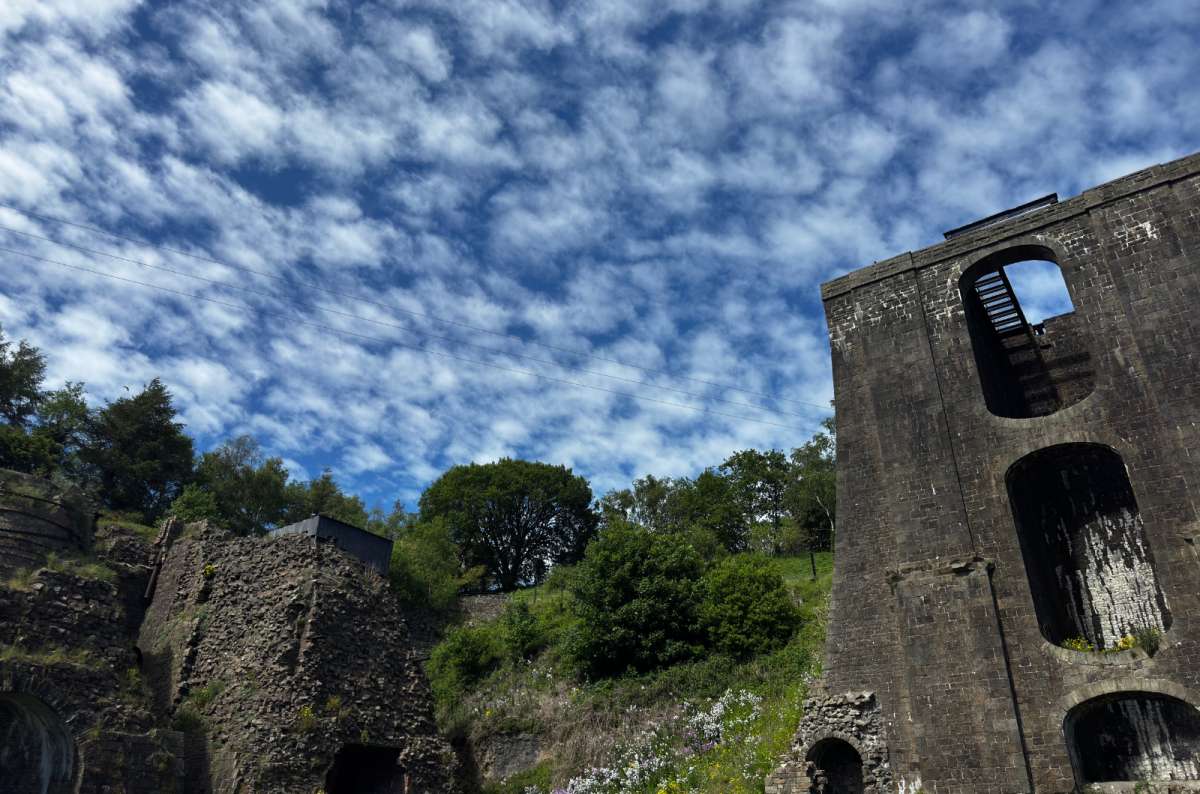 a photo of the 18th century furnace ruins of the Blaenavon Ironworks under a bright mackerel sky, Blaenavon, Wales, photo by Next Level of Travel