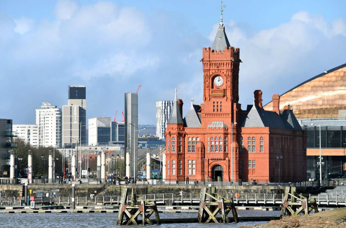 a photo of the red-brick Pierhead Building and Cardiff Bay with the city skyline behind, Cardiff, Wales