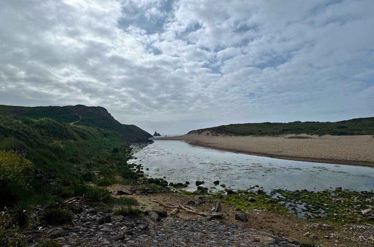 a photo of the sandy beach and tidal channel at Broad Haven South near Bosherston with Church Rock offshore, Bosherston, Wales, photo by Next Level of Travel