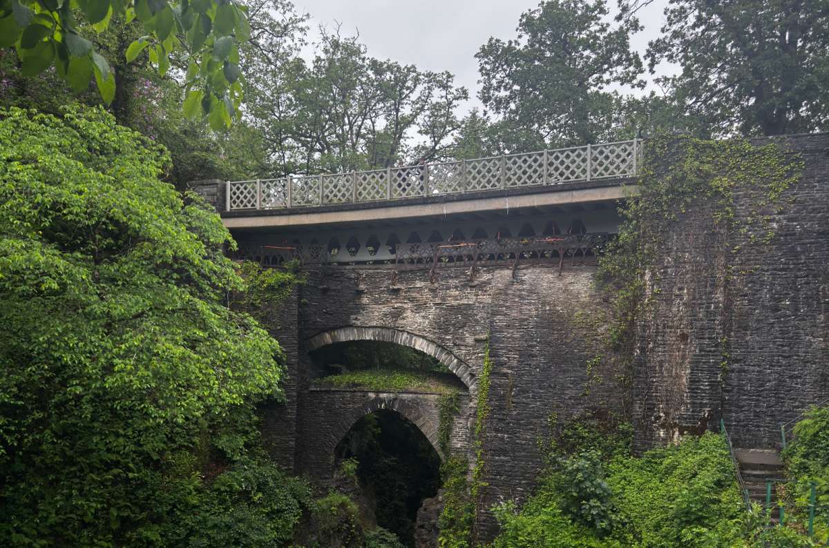 a photo of the stacked arches of Devil's Bridge over the wooded gorge, Devil's Bridge, Wales, photo by Next Level of Travel