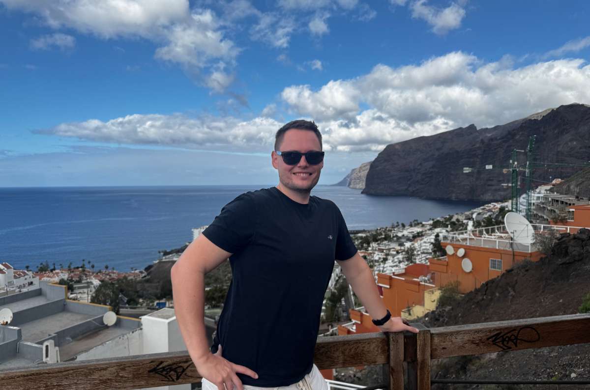 A tourist posing in front of a viewpoint, showing the cliffs of Los Gigantes, Tenerife, a photo by Next Level of Travel