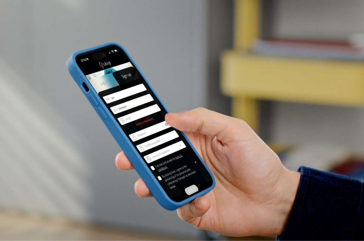 a photo of a hand holding a phone showing the Ubigi eSIM app sign up screen
