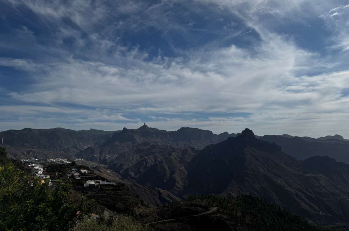 a photo of a sweeping panorama of central Gran Canaria's peaks and ravines with a white village clinging to a ridge, near Tejeda, Canary Islands, photo by Next Level of Travel