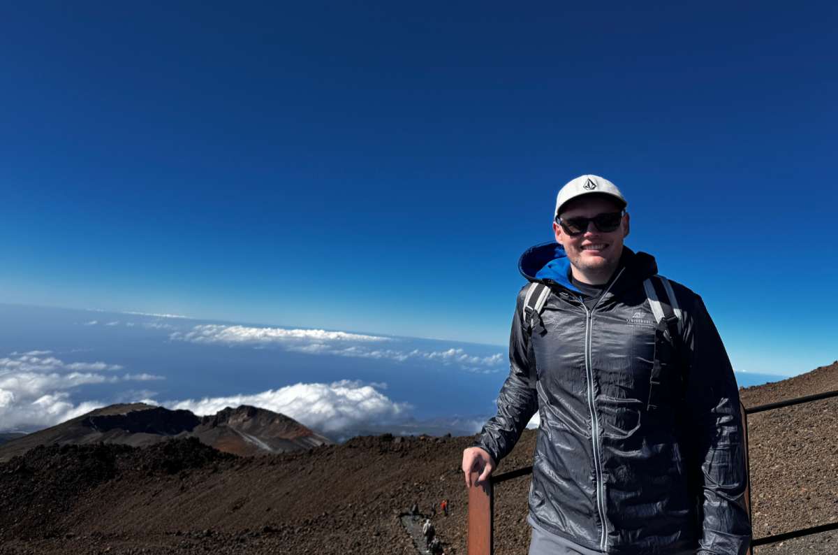 a photo of a tourist above the clouds with Pico Viejo's crater in the background, Mount Teide, photo by Next Level of Travel