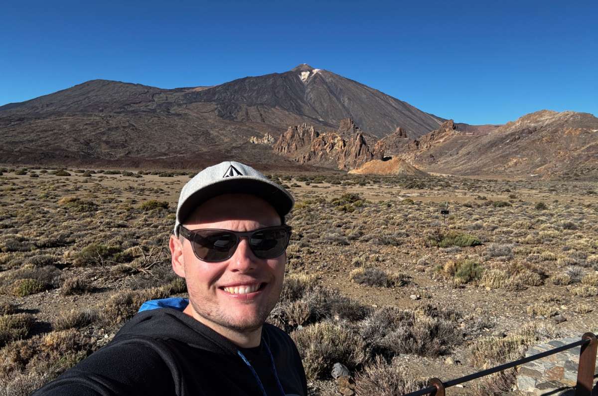a photo of a tourist with Mount Teide and its volcanic rock formations in the background, Teide National Park, Tenerife, photo by Next Level of Travel