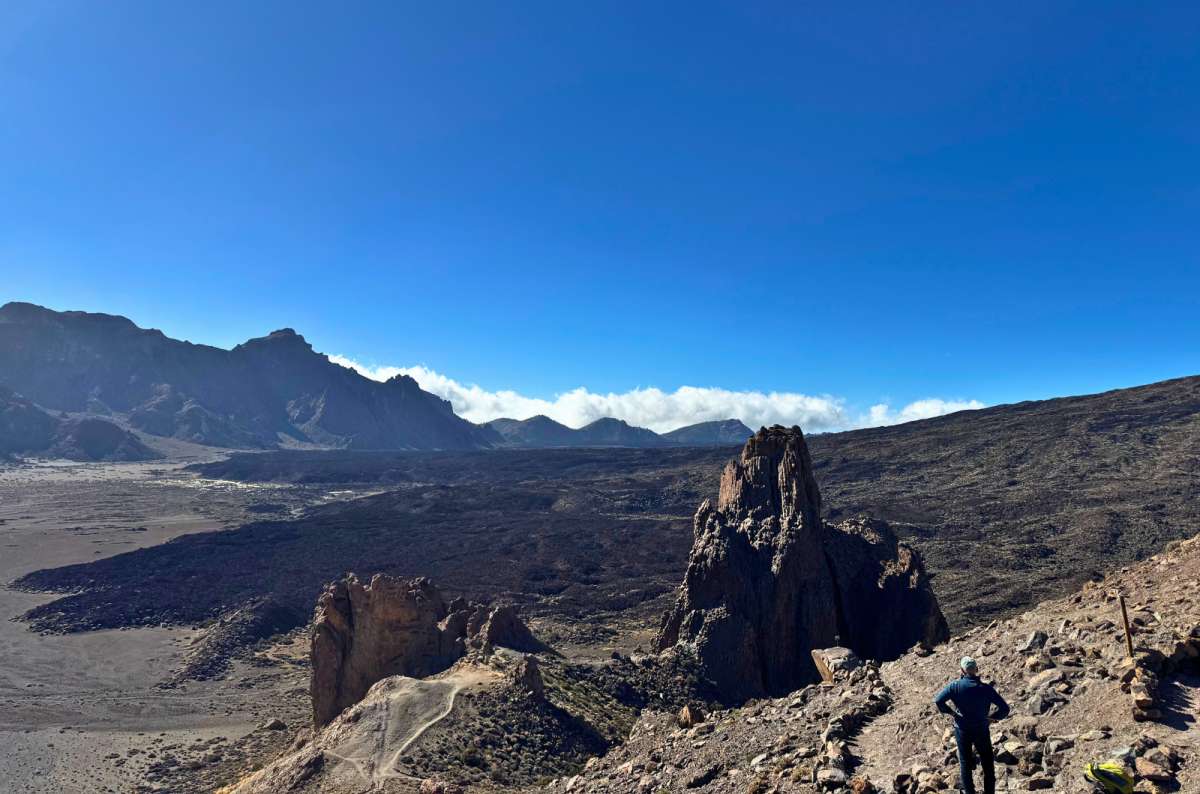 photo of a tourist overlooking the Roques de García rock formations and caldera, Teide National Park, photo by Next Level of Travel