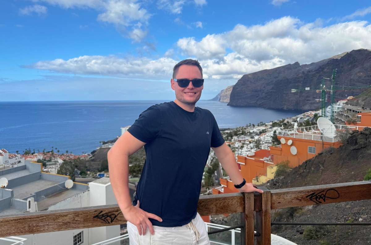 a photo of a tourist overlooking the coastal town and sea cliffs, Los Gigantes, Tenerife, photo by Next Level of Travel