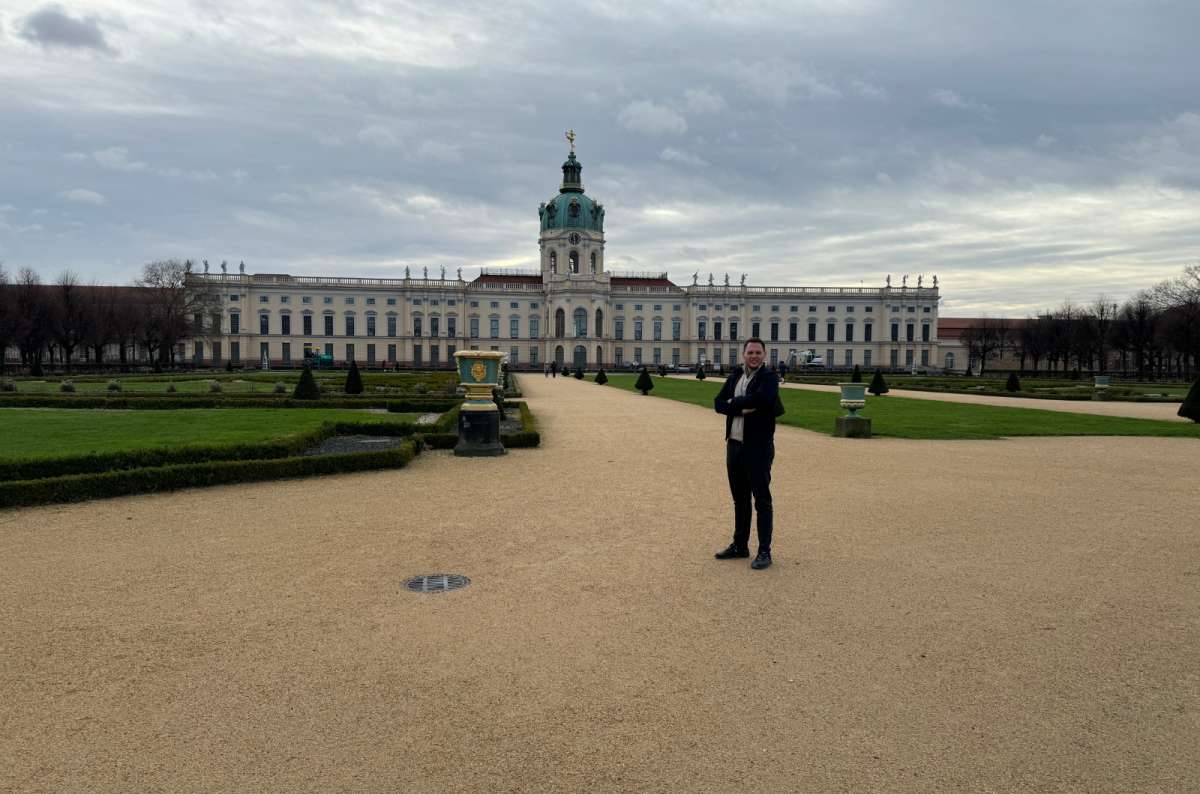 A photo showing a tourist posing in front of the Charlottenburg Palace, Germany, a photo by Next Level of Travel