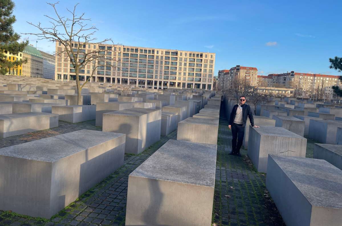 A photo showing a tourist walking between blocs of the Holocaust Memorial in Berlin, Germany, a photo by Next Level of Travel