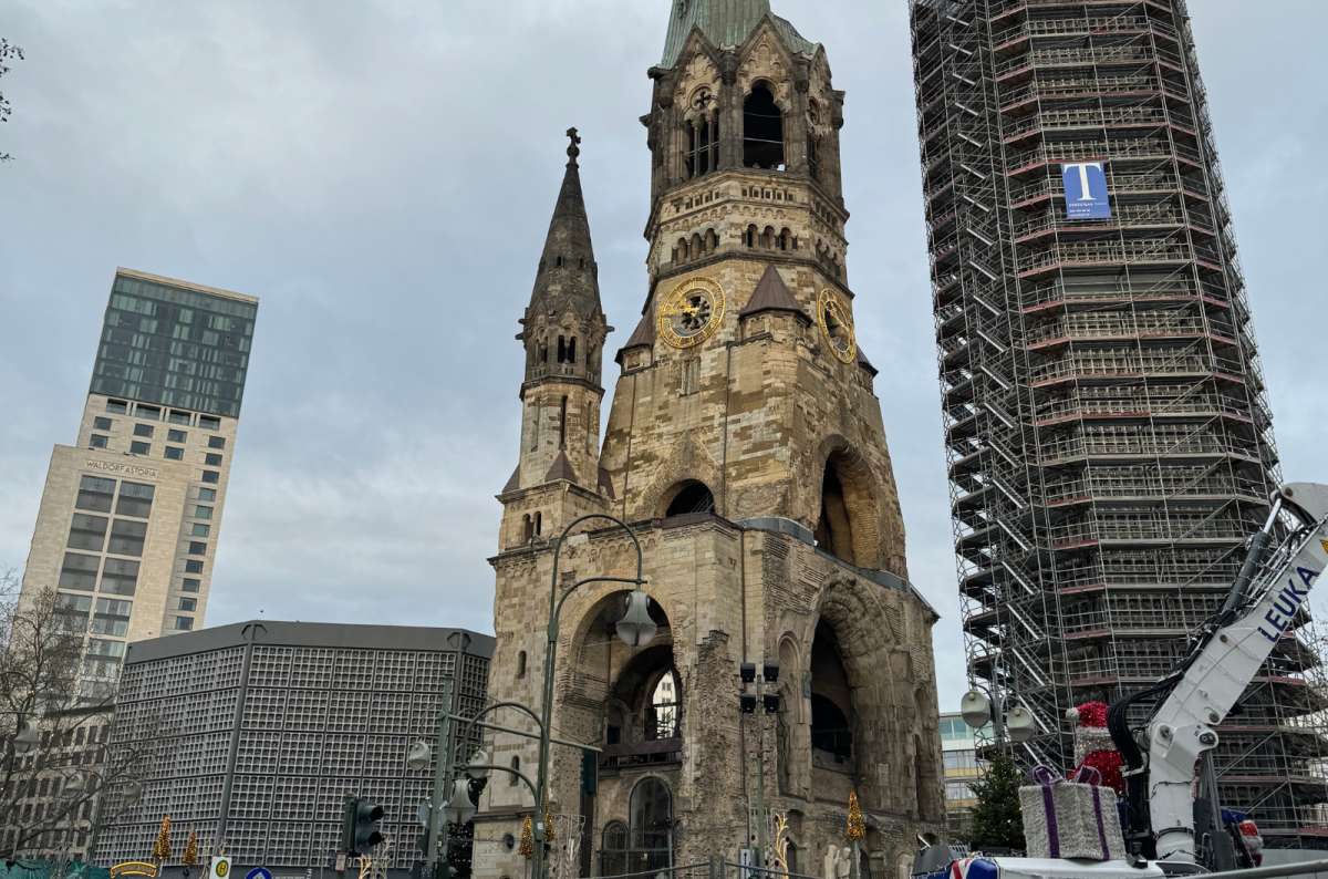 A photo showing the Kaiser Wilhelm Memorial Church surrounded by modern buildings in Berlin, Germany, a photo by Next Level of Travel