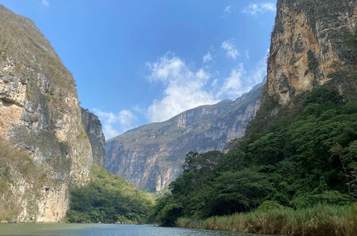 a photo of the towering green cliffs of Sumidero Canyon above the river, Chiapas, Mexico, photo by Next Level of Travel