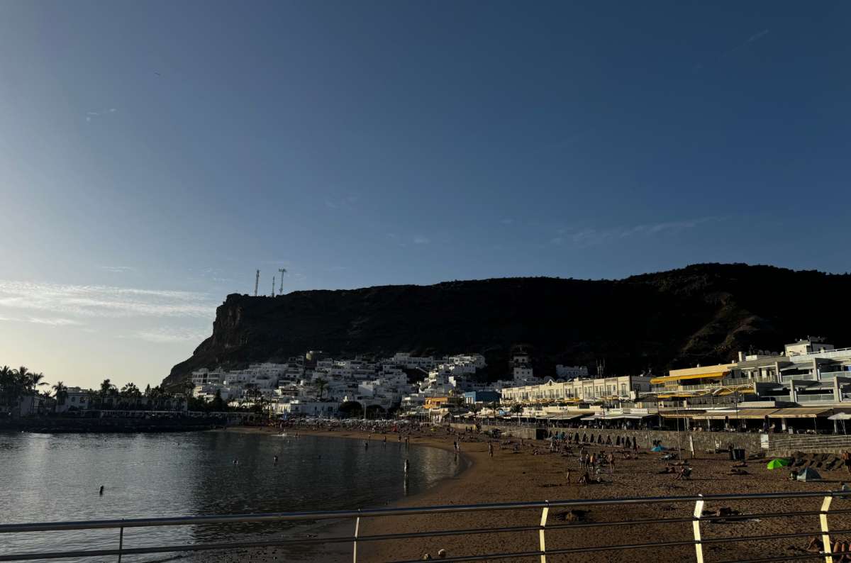 a photo showing the beach in Puerto de Mogán, showing the beautiful sand, cliffs in the background, Canary Islands, photo by Next Level of Travel