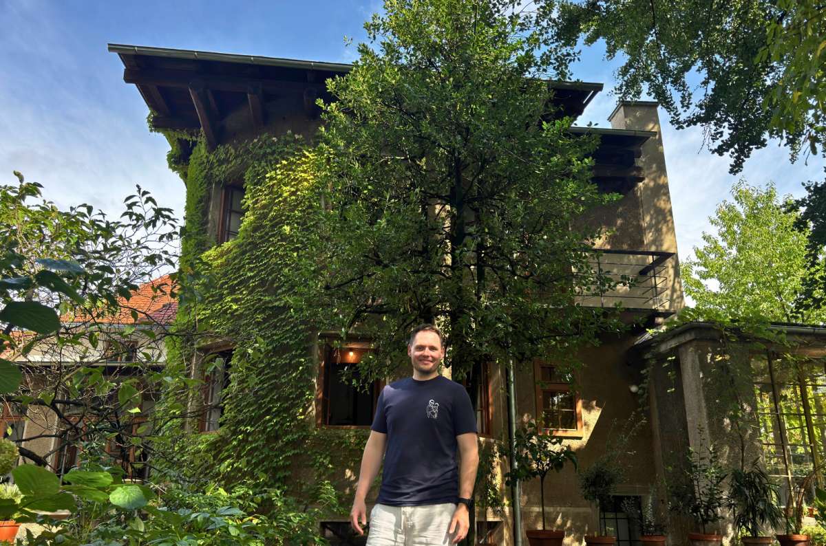 a photo of a tourist in front of the ivy-covered Plečnik House and its garden in Ljubljana, Slovenia, photo by Next Level of Travel
