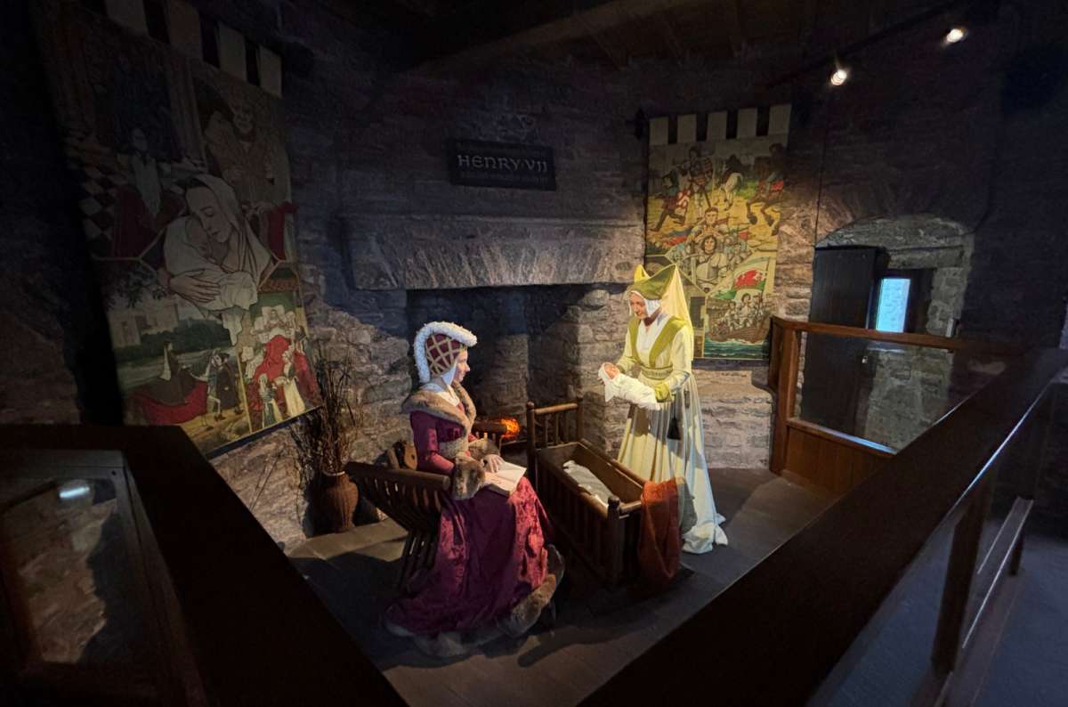 a photo of a costumed scene of the birth of Henry VII in a stone chamber, Pembroke, Wales, photo by Next Level of Travel