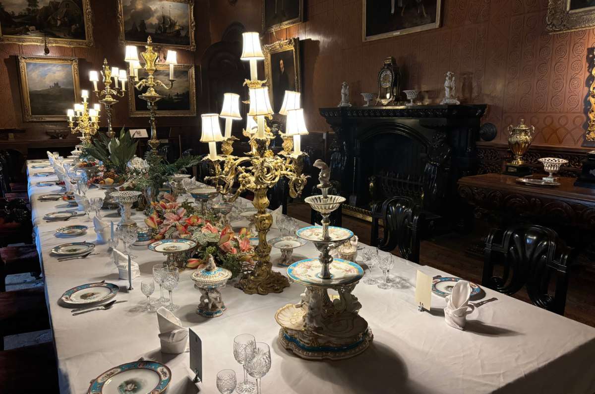 a photo of a lavishly set dining table with gilded candelabras inside Penrhyn Castle, Bangor, Wales, photo by Next Level of Travel