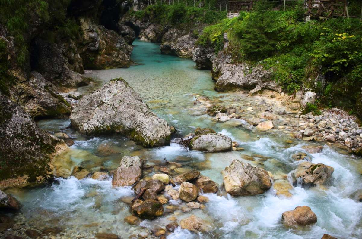 a photo of a turquoise river running over boulders, Tolmin Gorges, Slovenia