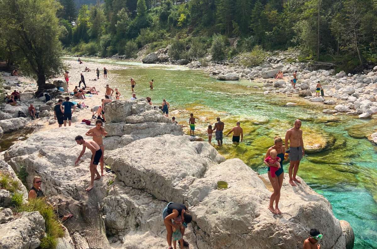 a photo of crowds of swimmers on the rocks and in the turquoise Soča River, Great Soča Gorge, Slovenia, photo by Next Level of Travel