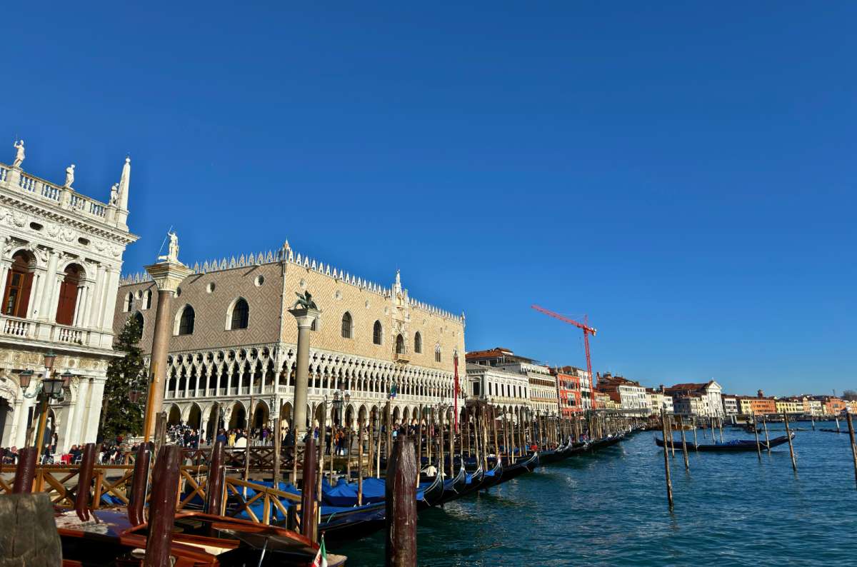 a photo of gondolas moored along Riva degli Schiavoni in front of Doge’s Palace and the column of St. Mark, Venice, Italy, photo by Next Level of Travel