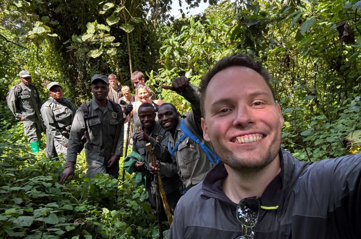 a photo of a tourist taking a selfie with park rangers in the jungle, Volcanoes National Park, Rwanda, photo by Next Level of Travel