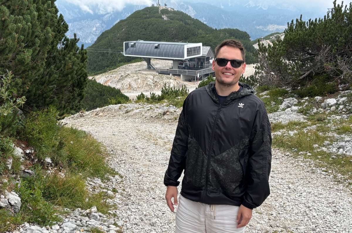 a photo of a tourist on a gravel path on Vogel with the upper cable car station behind him, Vogel, Slovenia, photo by Next Level of Travel