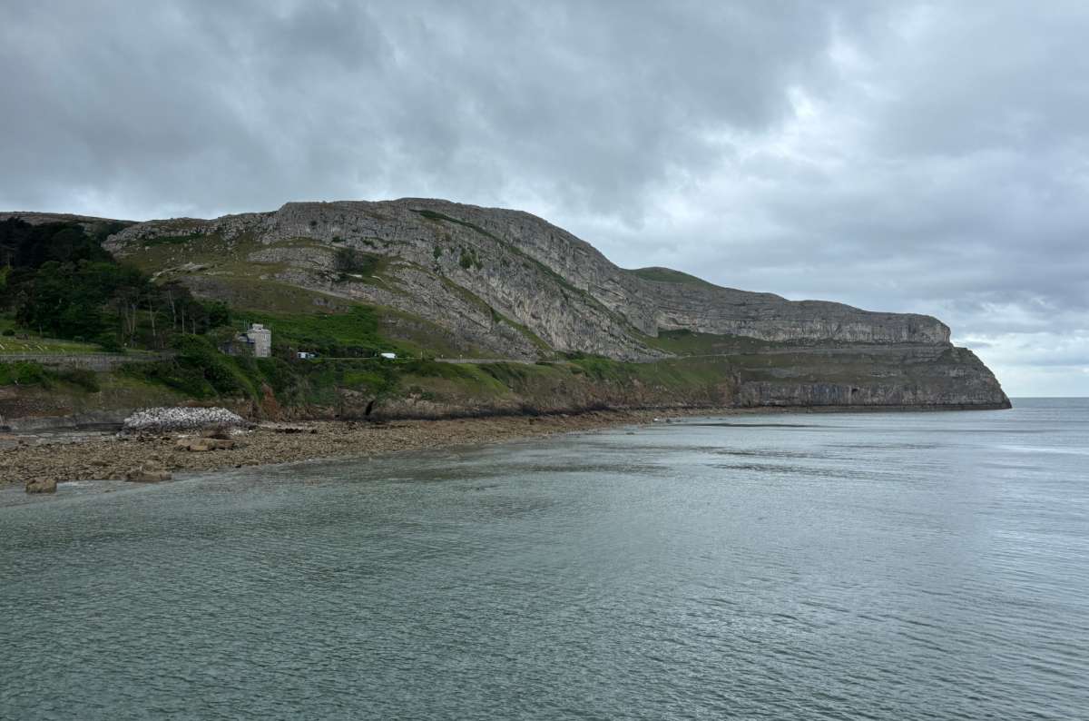 a photo of the shingle beach of Llandudno North Shore under a blue sky, Wales, photo by Next Level of Travel