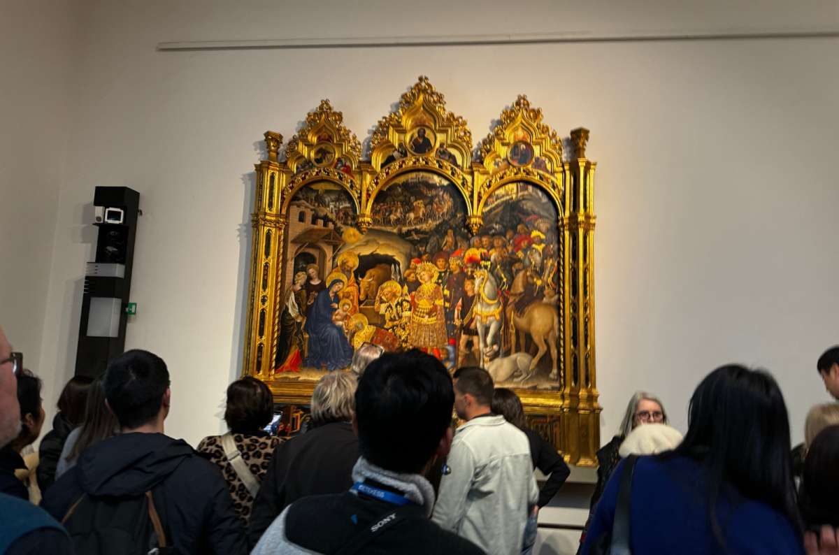 a photo of a crowd of visitors packed in front of a golden altarpiece in the Uffizi Gallery, Florence, Italy, photo by Next Level of Travel