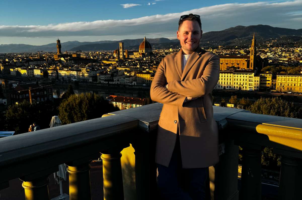 a photo of a tourist leaning on the balustrade at Piazzale Michelangelo with the Florence skyline, Italy, photo by Next Level of Travel