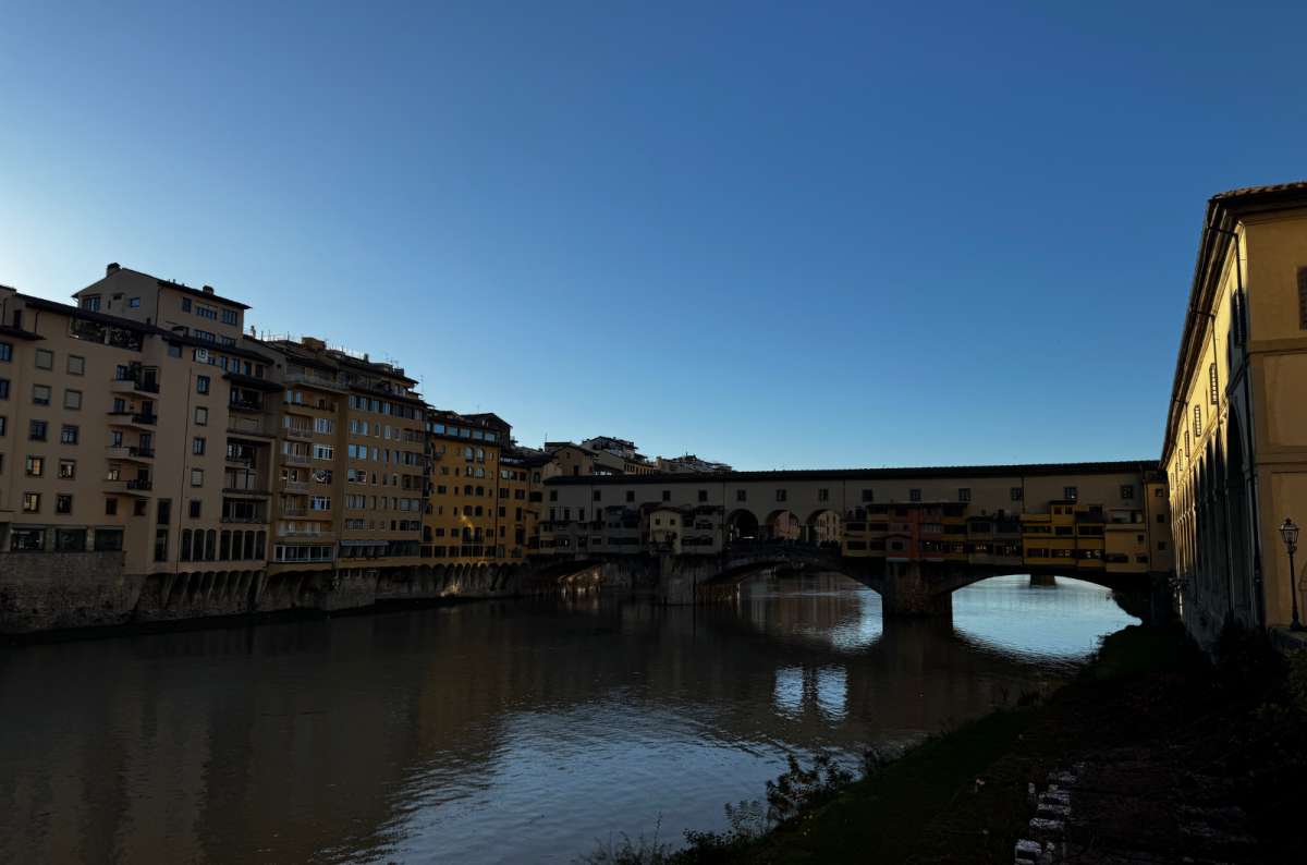 a photo of Ponte Vecchio at dusk seen from downstream along the Arno, Florence, Italy, photo by Next Level of Travel